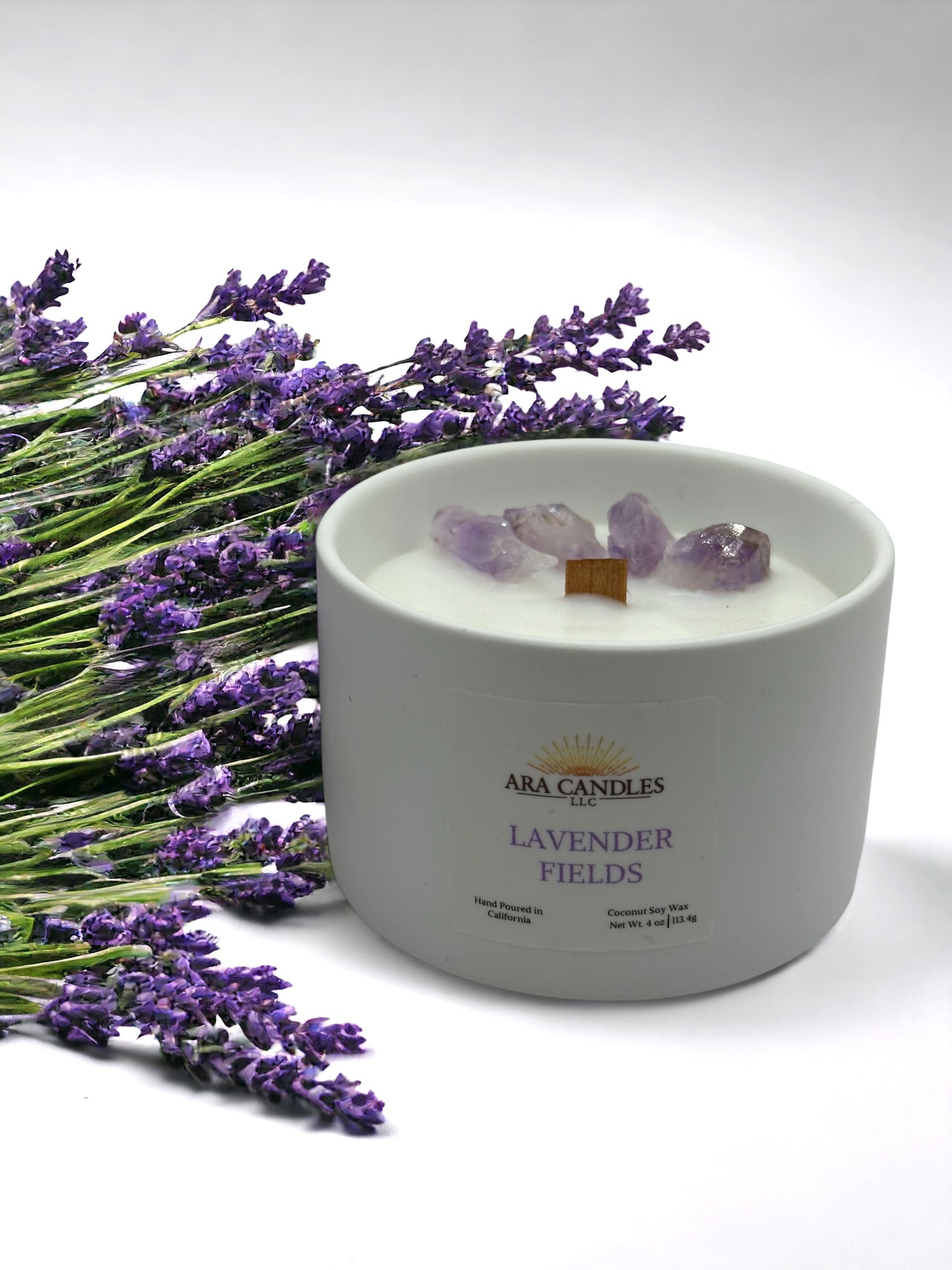4 oz Lavender Fields candle with lavender flowers in the background and amethyst crystals on top of the wax, offering a soothing lavender fragrance and a calming, decorative touch