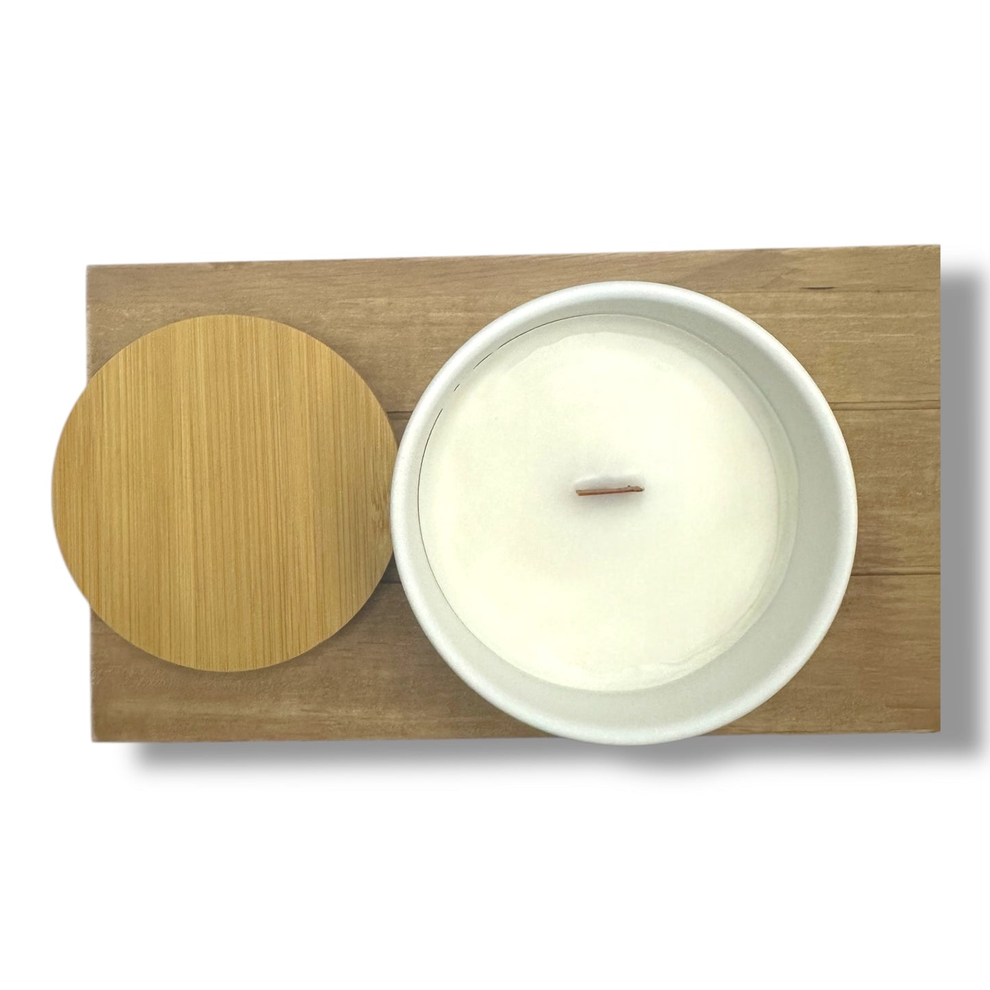 Top view of BREATHE ritual candle with bamboo lid on wooden board background