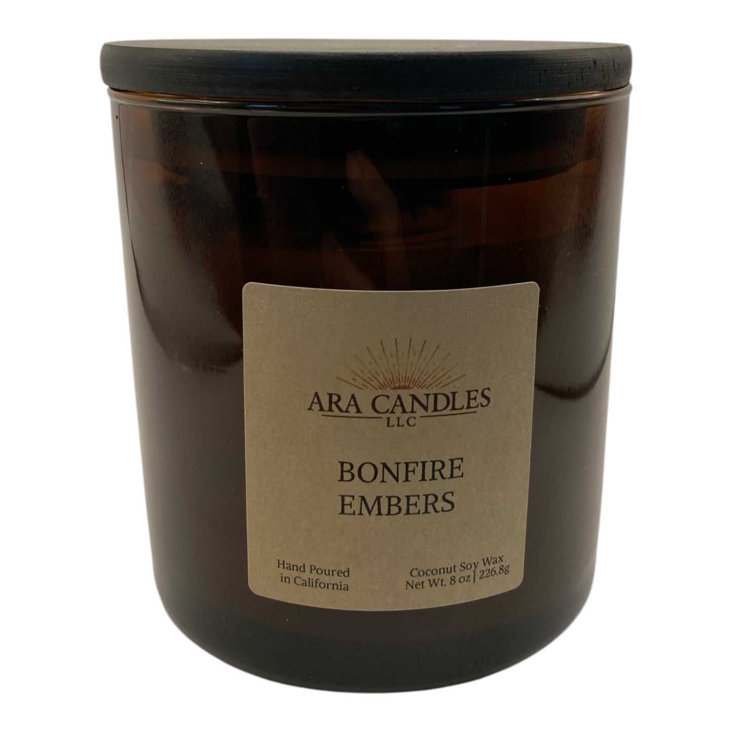Bonfire Embers flameless 8 oz candle in an amber jar with a black lid, set against a white background, offering a warm, smoky bonfire fragrance in a flame-free form