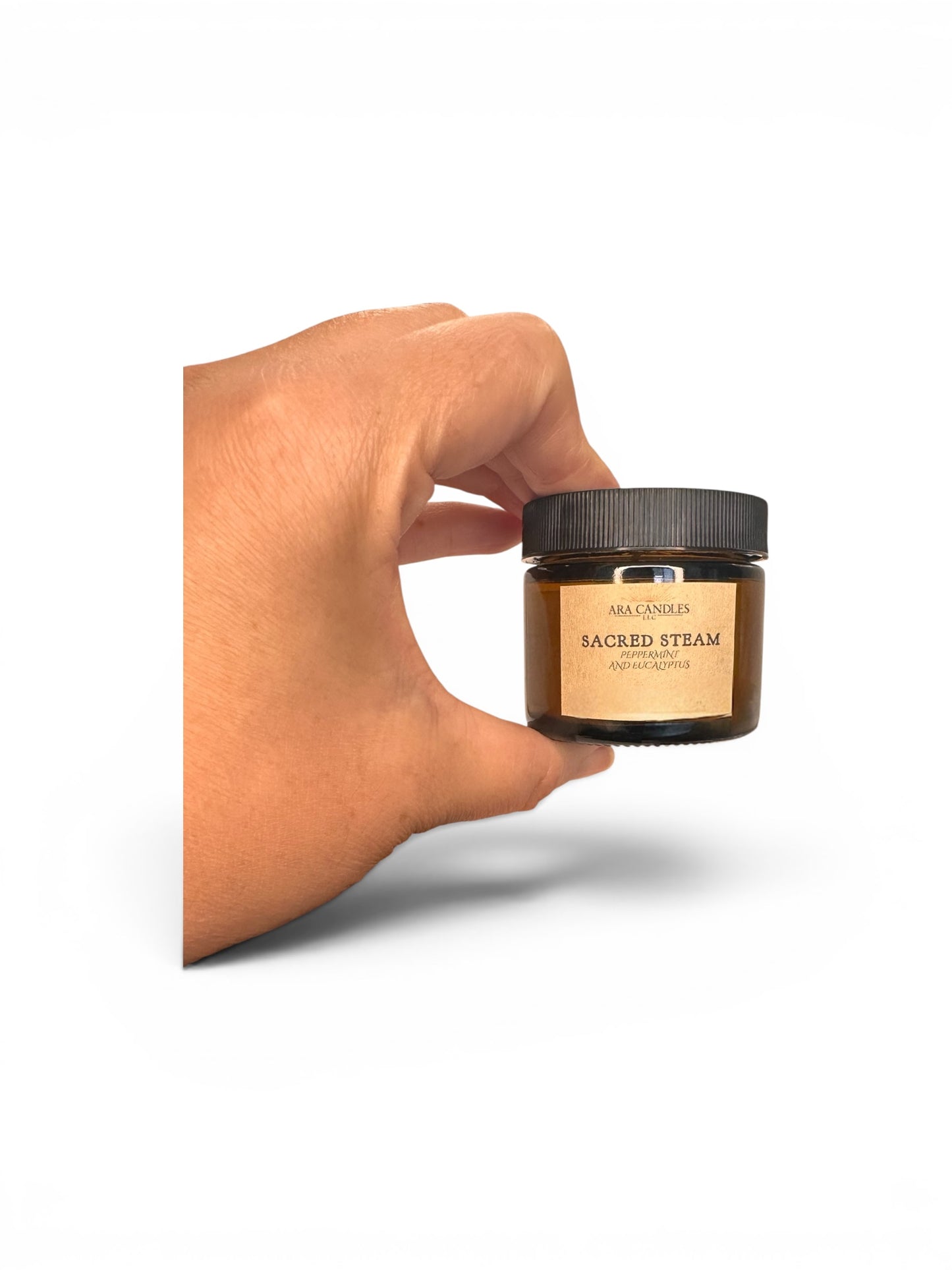 Hand holding a jar labeled 'Sacred Steam' against a white background