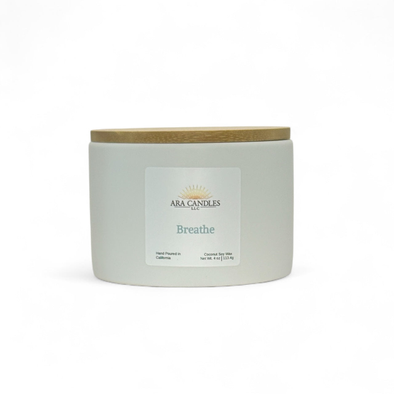 White ceramic candle labeled Breathe from Ara Candles, with wooden lid, designed for clarity and breath work rituals.