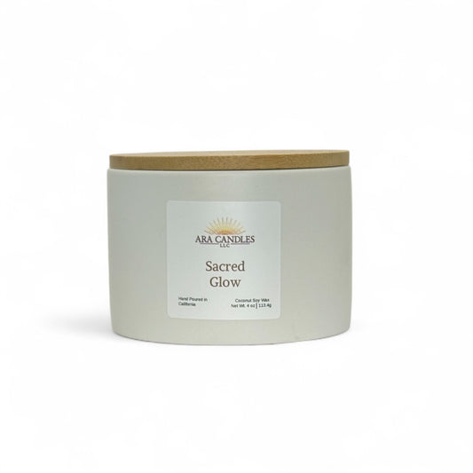 Sacred Glow candle from ARA Candles, minimalist white vessel with grounding palo santo and grapefruit scent. 