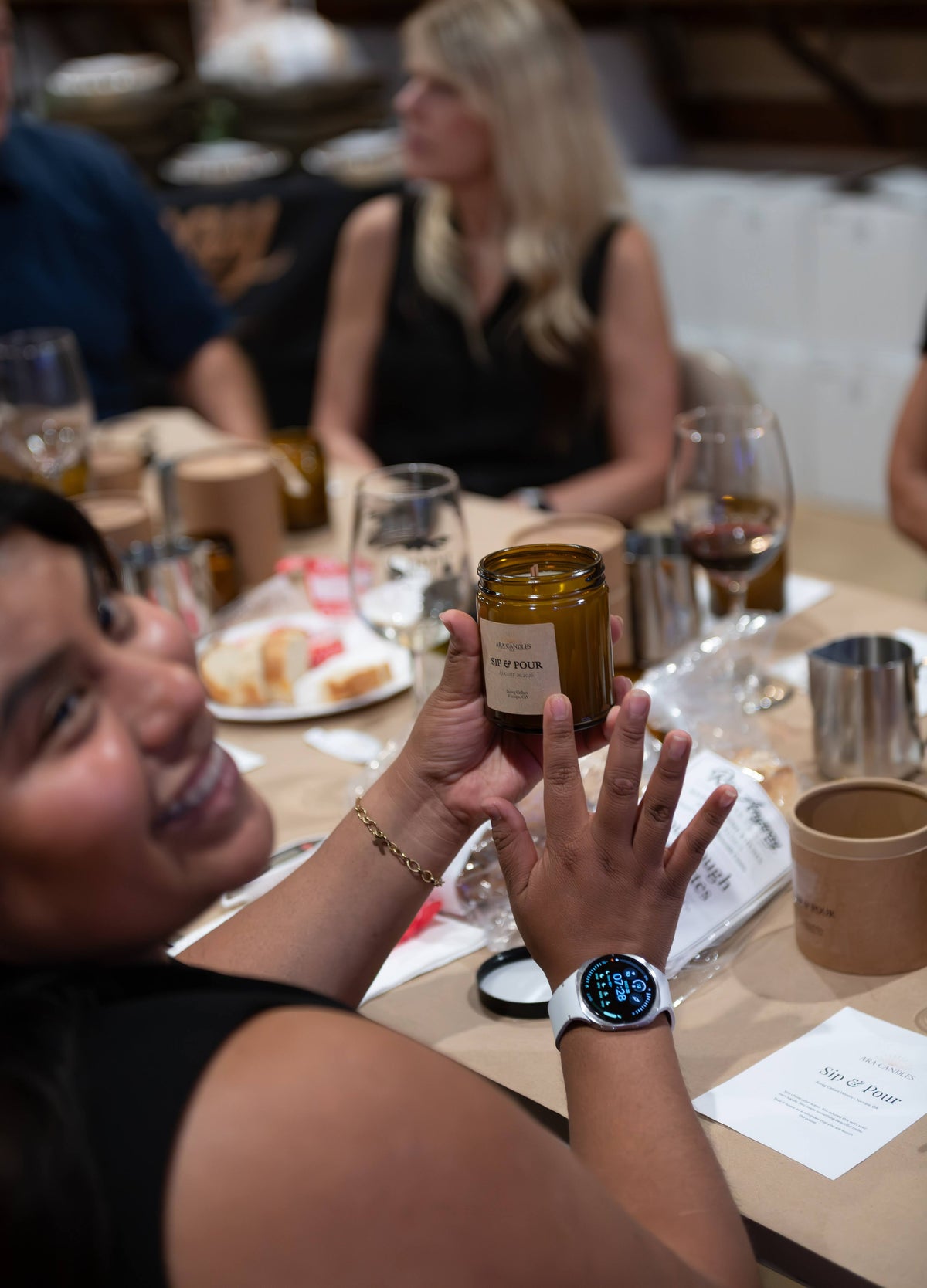 A female labeling her candle she just poured at the SIP N POUR event. 