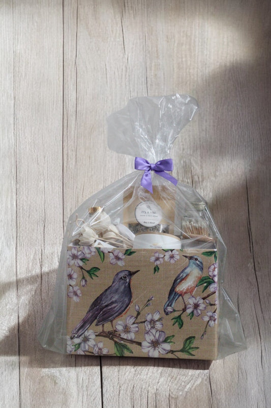 Mother’s Day gift box with purple bird design, lavender and apricot-scented candles, car diffuser, rose reed diffuser, bath soak, and matches