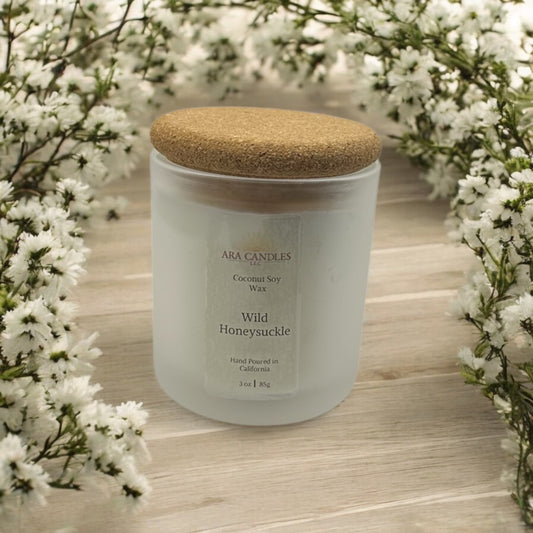 Ara Candles Wild Honeysuckle coconut soy candle with hints of jasmine and fresh greenery, styled for spring with soft natural light and floral accents