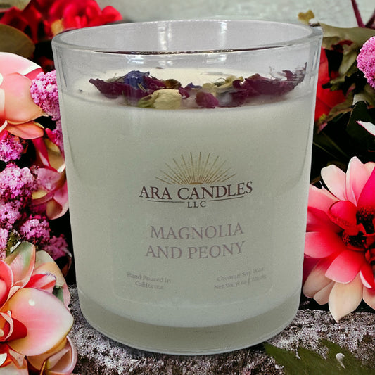 Magnolia and Peony flameless 8 oz candle surrounded by a beautiful floral backdrop, offering a fragrant floral aroma to create a soothing and elegant ambiance without the flame