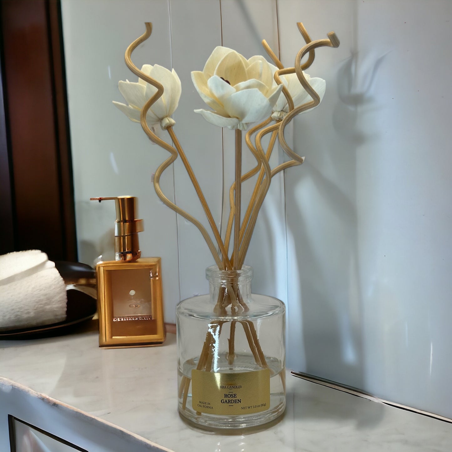 Rose Garden reed diffuser with flower-shaped wooden sticks and spiral reeds, creating a soothing floral rose fragrance in a tranquil bathroom setting